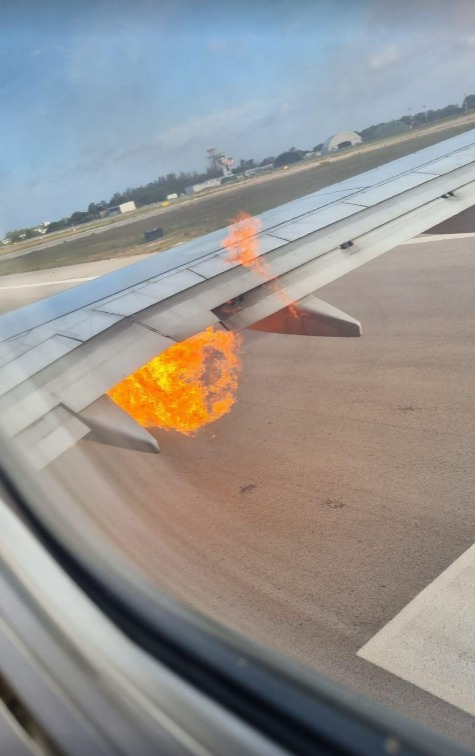 an airplane wing with flames coming out of it