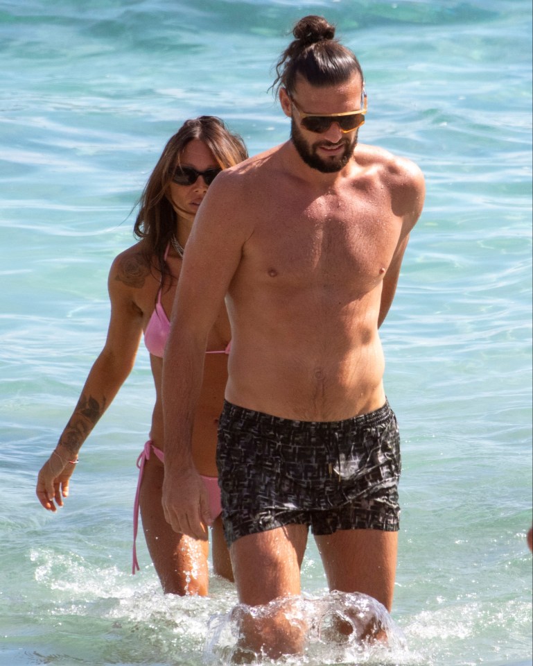 a man and a woman are walking out of the water