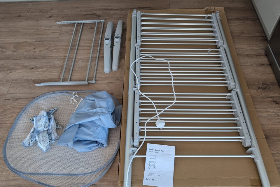 a clothes drying rack is sitting on a wooden floor