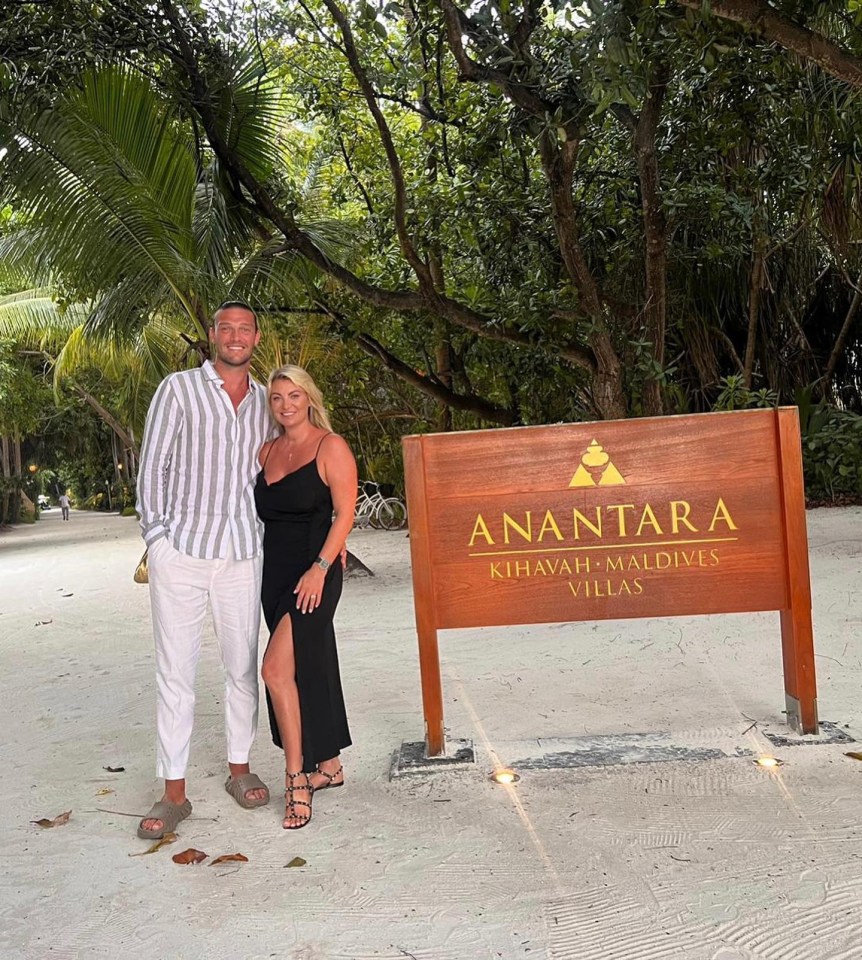 a man and woman standing in front of a sign that says anantara