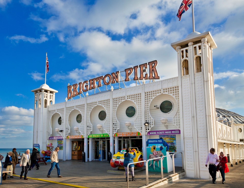 people are walking around the brighton pier building