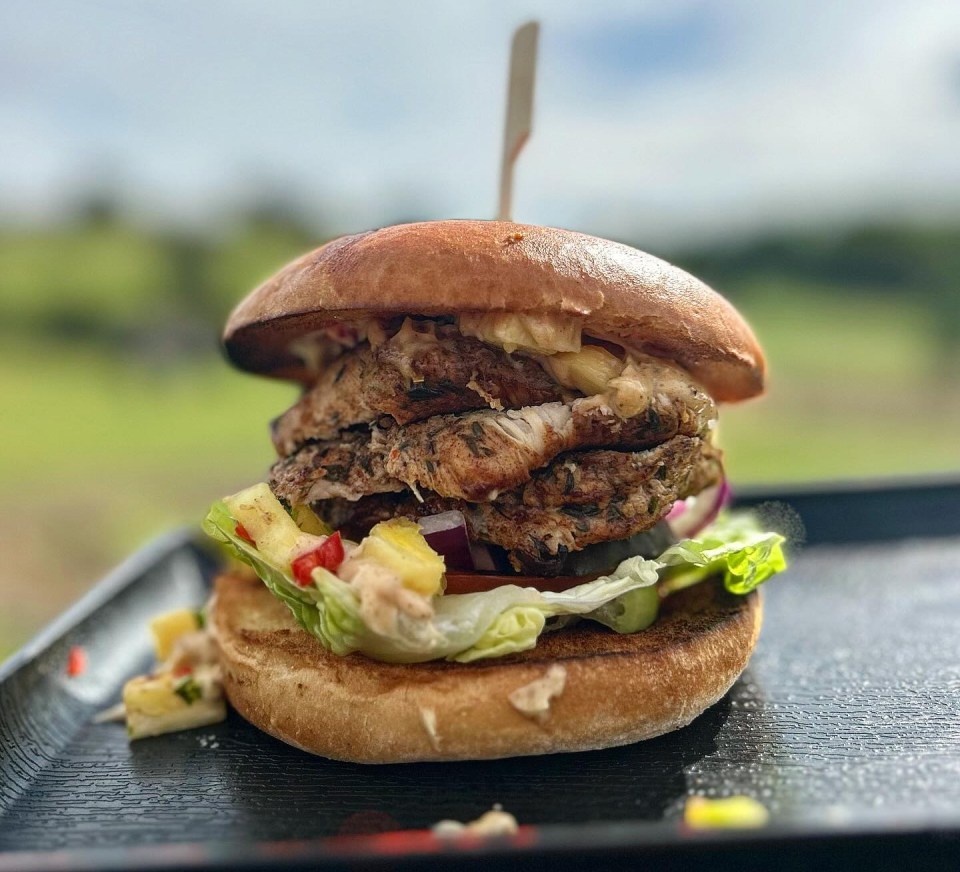 a close up of a hamburger on a tray with a toothpick sticking out of it