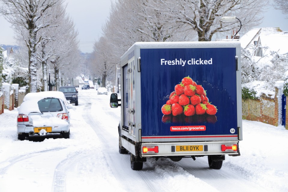 a tesco truck drives down a snowy road