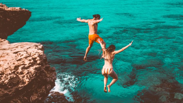 Couple jumping in the sea