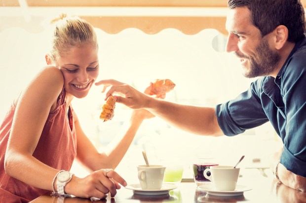 a man is feeding a woman a piece of bread