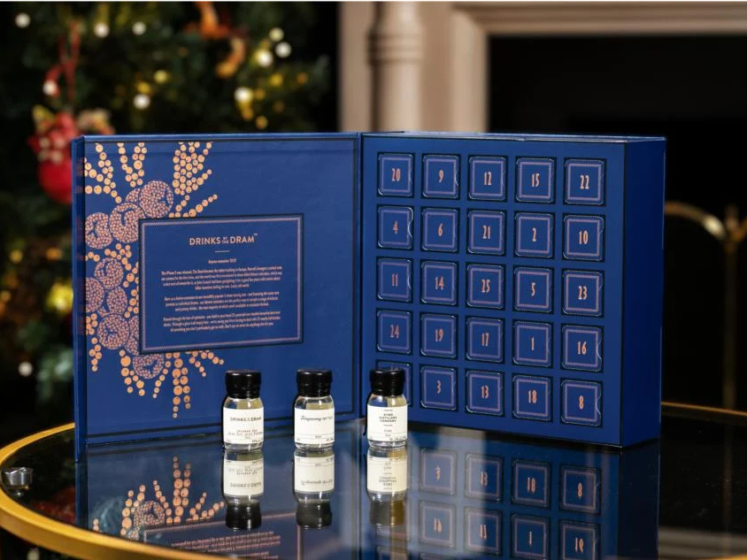 a drinksogram advent calendar with a christmas tree in the background