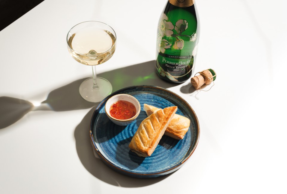 a bottle of perrier jouet champagne next to a plate of food