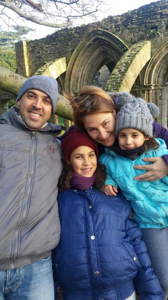 a family poses for a picture in front of a ruined building