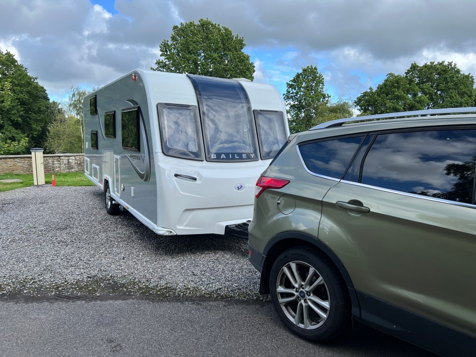 a bailey caravan is being towed by a green suv