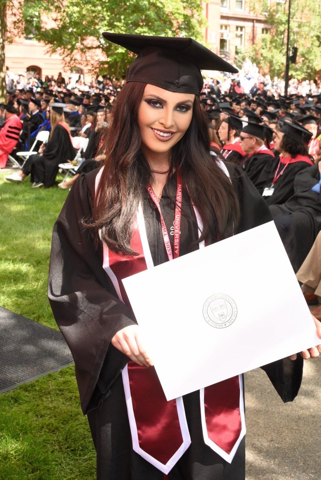 a woman in a graduation cap and gown is holding a diploma from harvard university