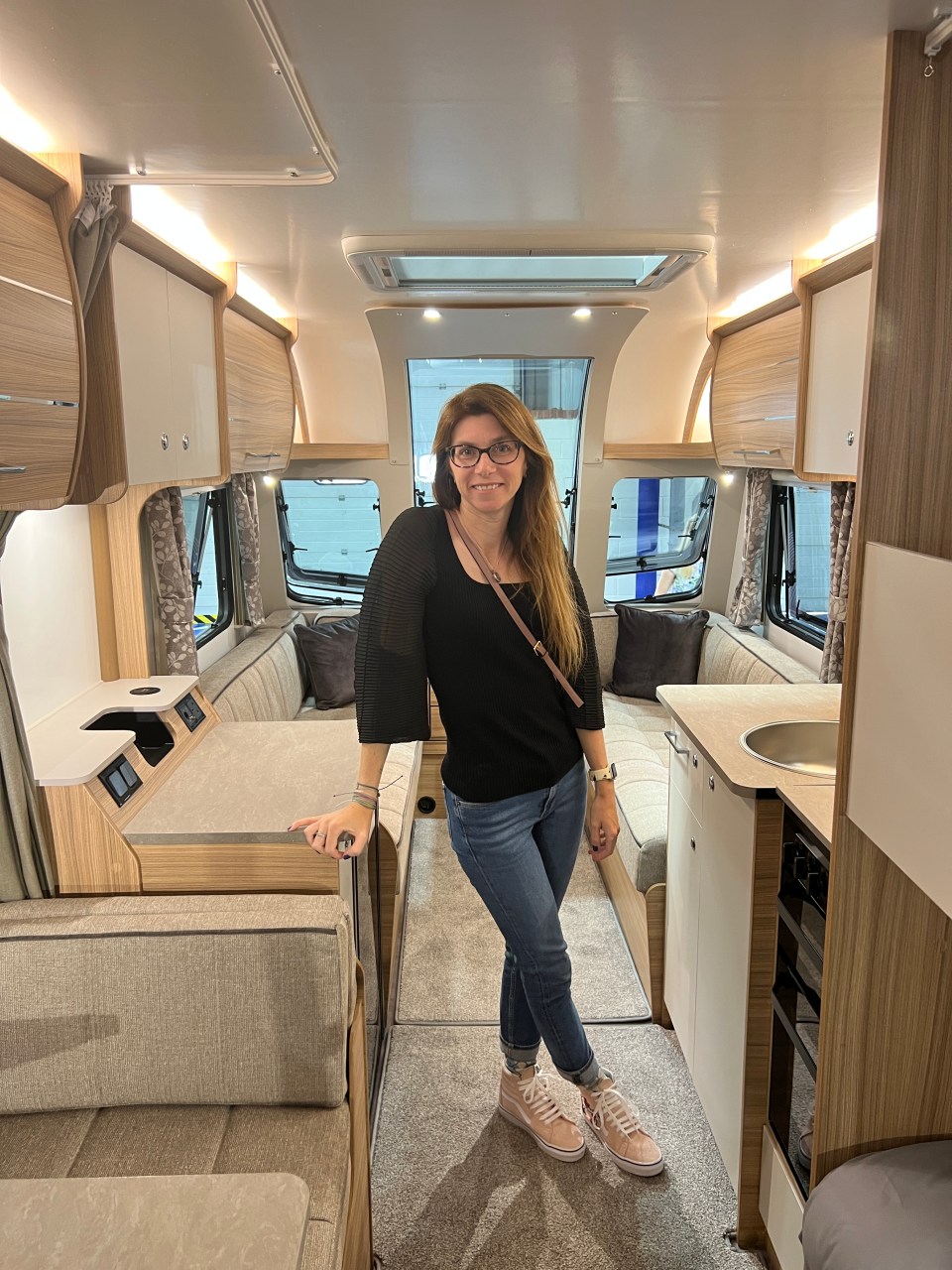 a woman wearing glasses is standing in a camper