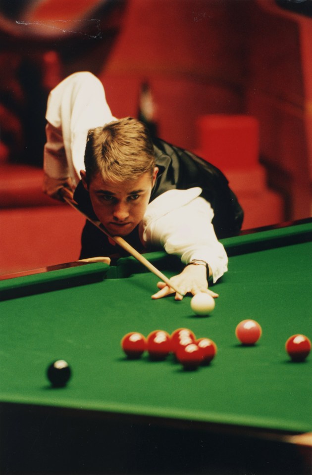 a man in a white shirt is playing pool