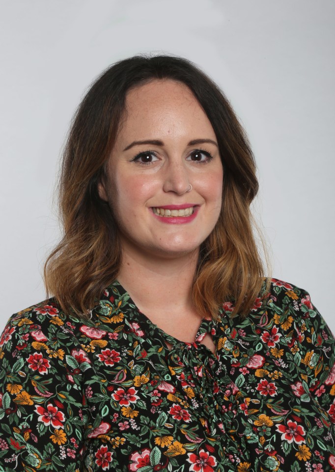 a woman wearing a floral shirt smiles for the camera