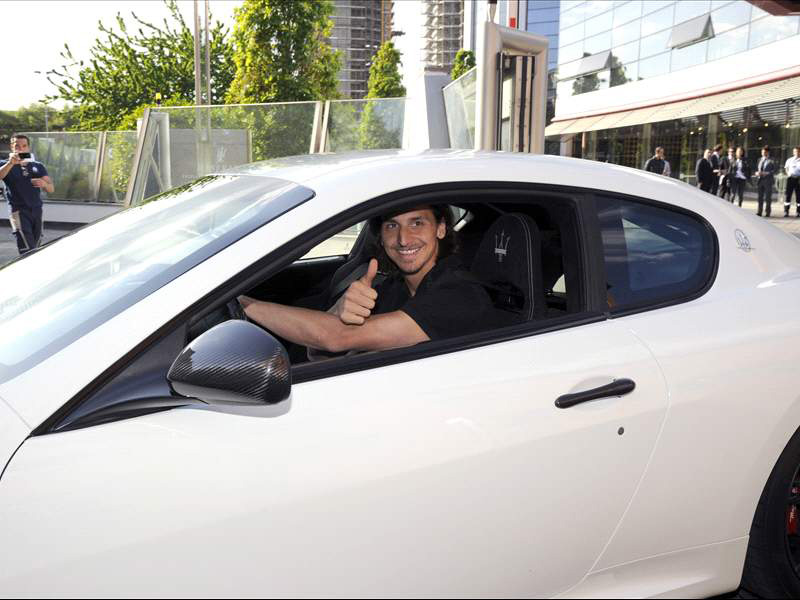 a man is giving a thumbs up while sitting in a white car