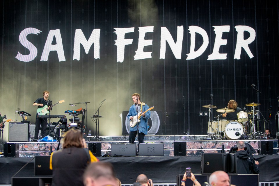 the band sam fender performs on stage at a concert