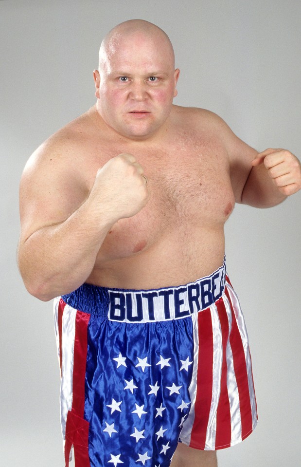 a bald man wearing boxing shorts that say butterbell