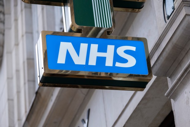 a nhs sign hangs from the side of a building