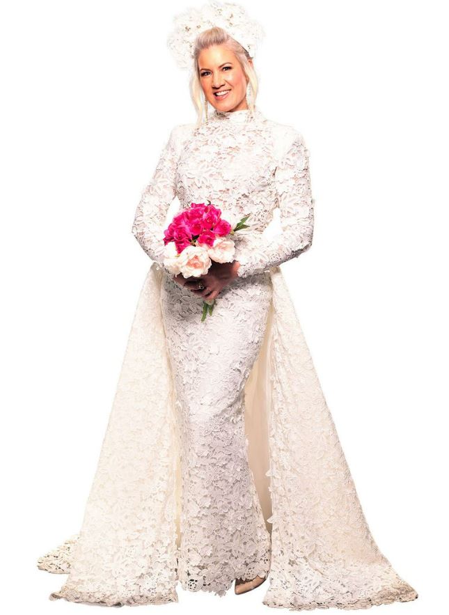 a woman in a wedding dress is holding a bouquet of pink flowers