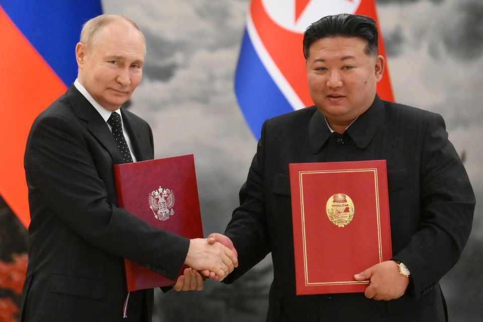 two men shaking hands with one holding a red book