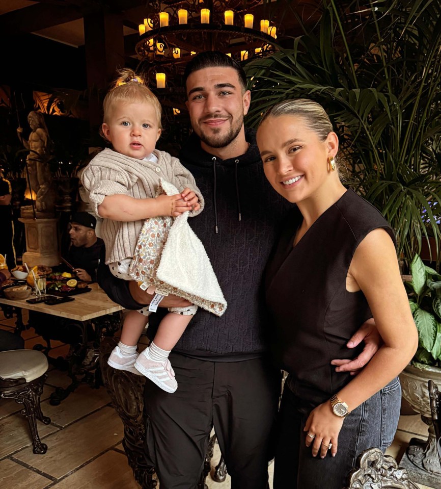 a man and woman are posing for a picture with a baby