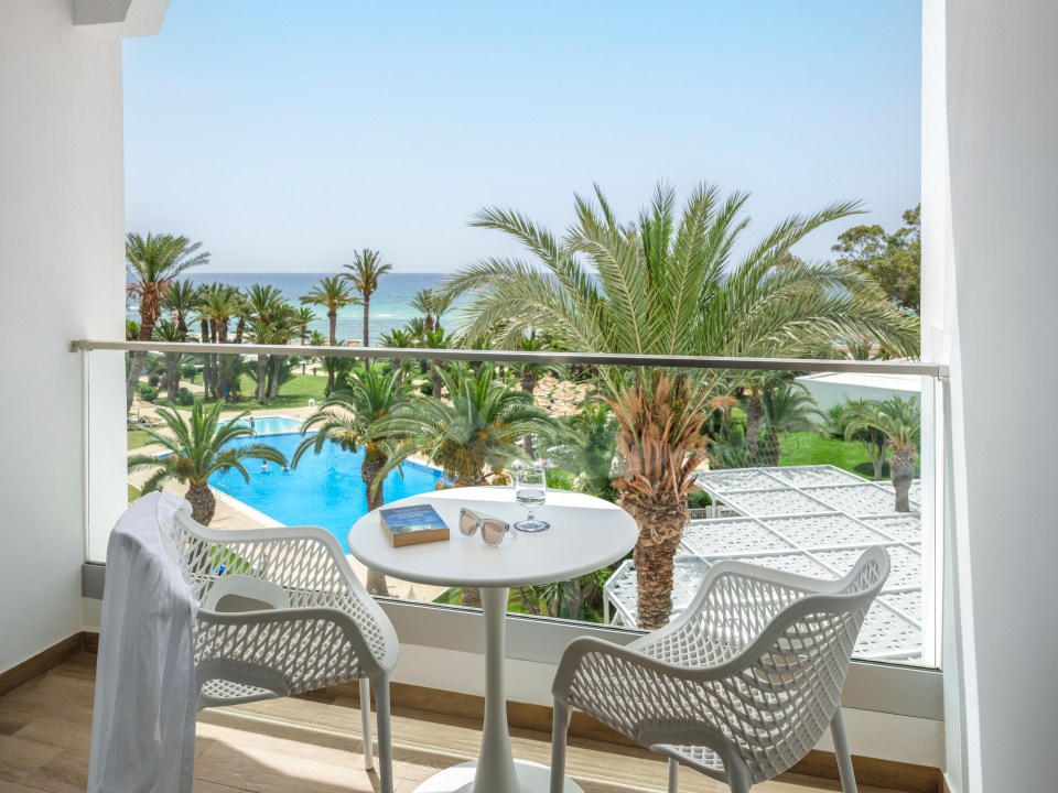 a balcony with two chairs and a table with a book on it