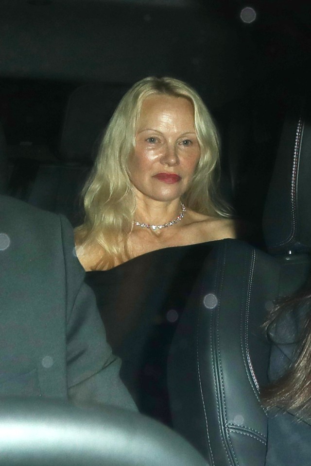 a woman with blonde hair and a necklace is sitting in a car