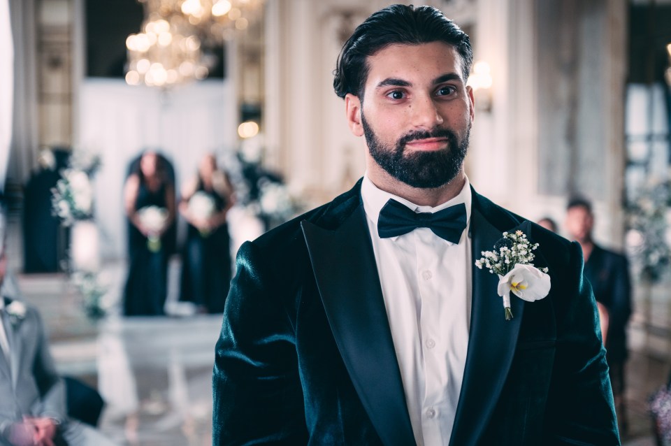 a man in a tuxedo has a white flower in his pocket