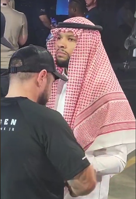 a man wearing a keffiyeh talks to another man