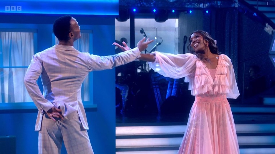 a woman in a pink dress is dancing with a man in a white suit