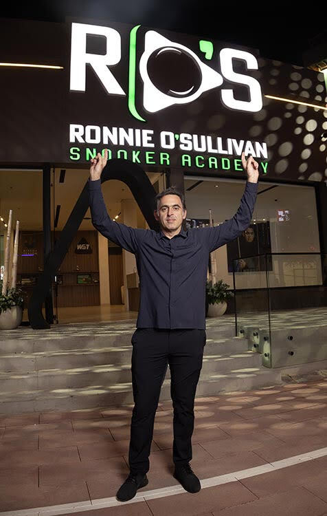 a man stands in front of ronnie o'sullivan snooker academy