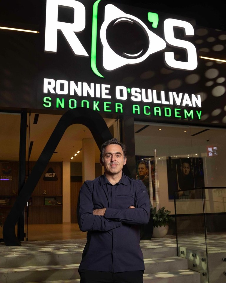 a man stands in front of ronnie o'sullivan snooker academy