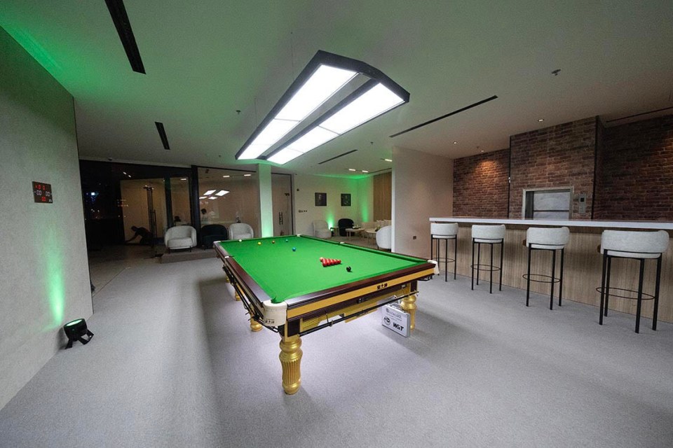 a pool table in a room with stools and chairs