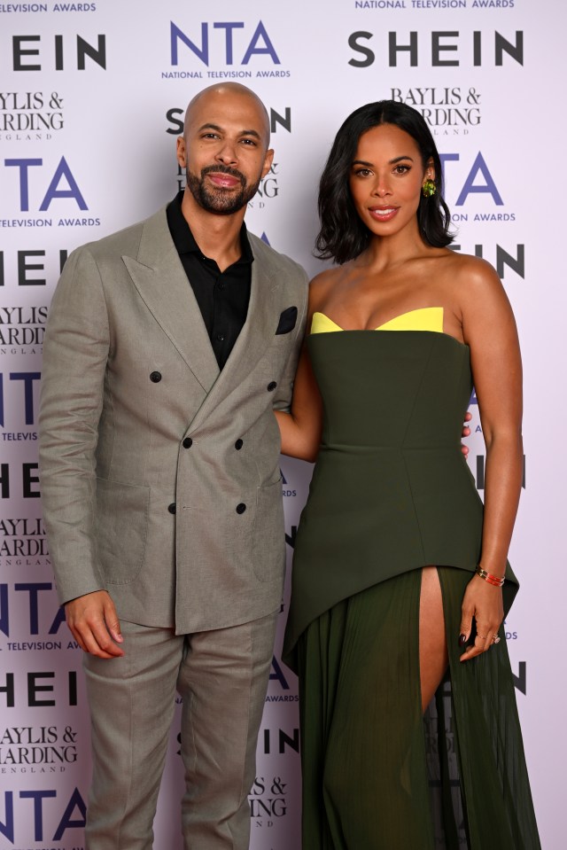 a man in a suit and a woman in a green dress pose on a red carpet at the nta television awards