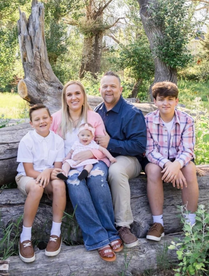 a family poses for a picture while sitting on a log