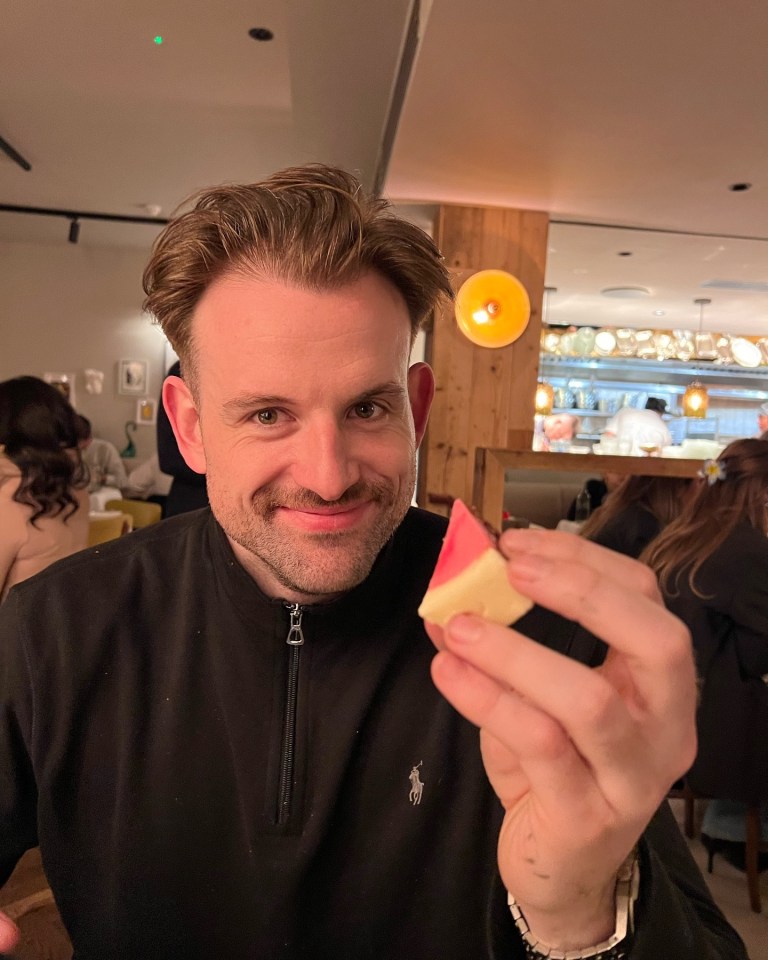 Her fiancé Mark was also all smiles as he held up a pink bit of the cake