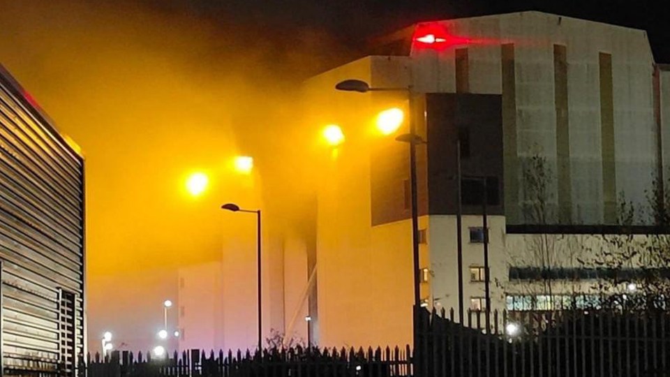 a building with smoke coming out of it at night