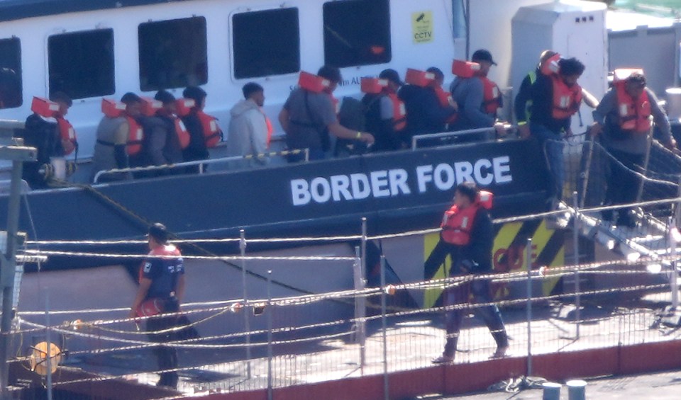 a group of people are boarding a boat that says border force