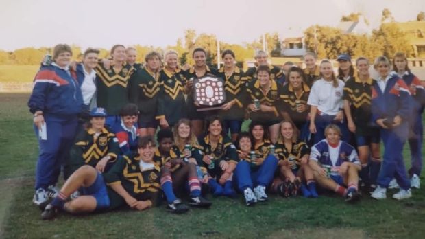 a group of people posing for a picture with a trophy that says ' rugby ' on it