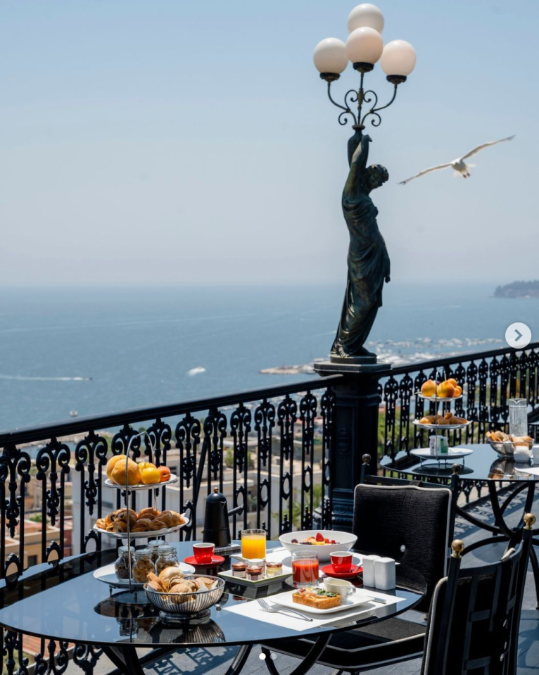 a table with a view of the ocean and a statue of a woman