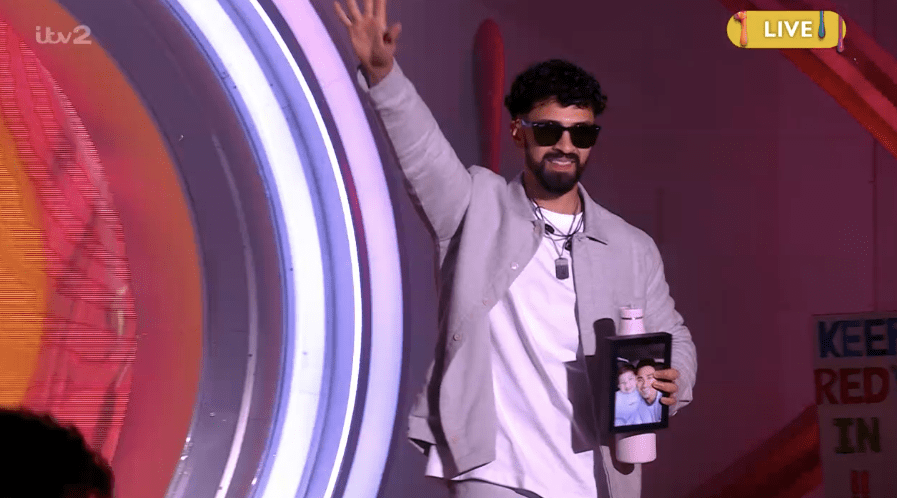 a man wearing sunglasses stands in front of a sign that says live