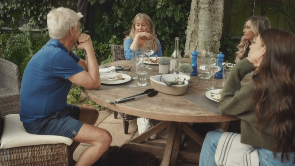 a group of people sit around a table with plates of food on it