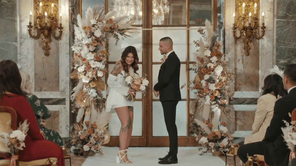 a bride and groom are getting married in front of a crowd of people