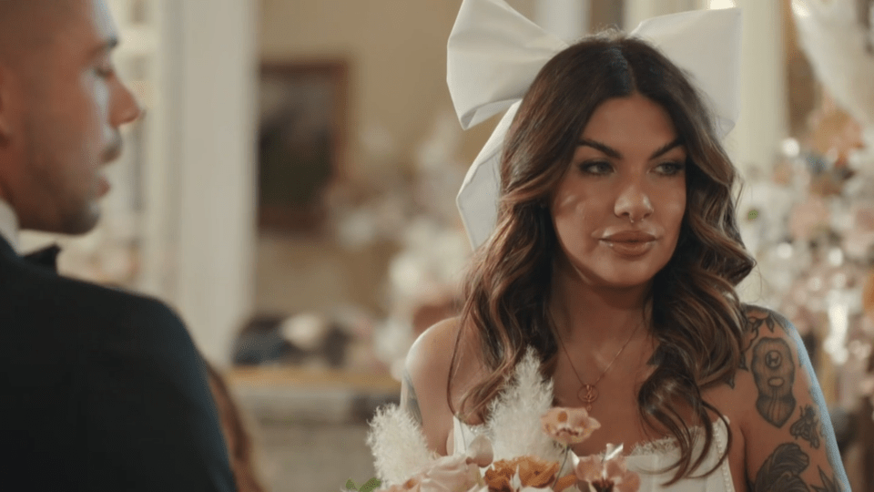 a woman in a wedding dress has a white bow on her head