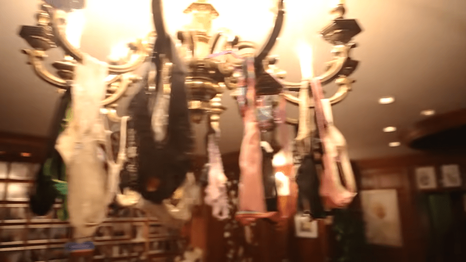 a chandelier with a bunch of clothes hanging from it