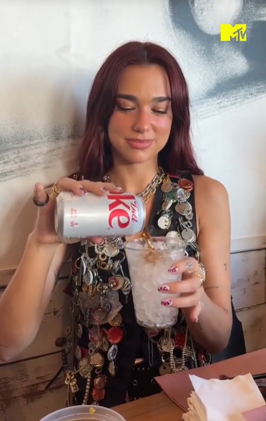 a woman is pouring diet coke into a cup of ice