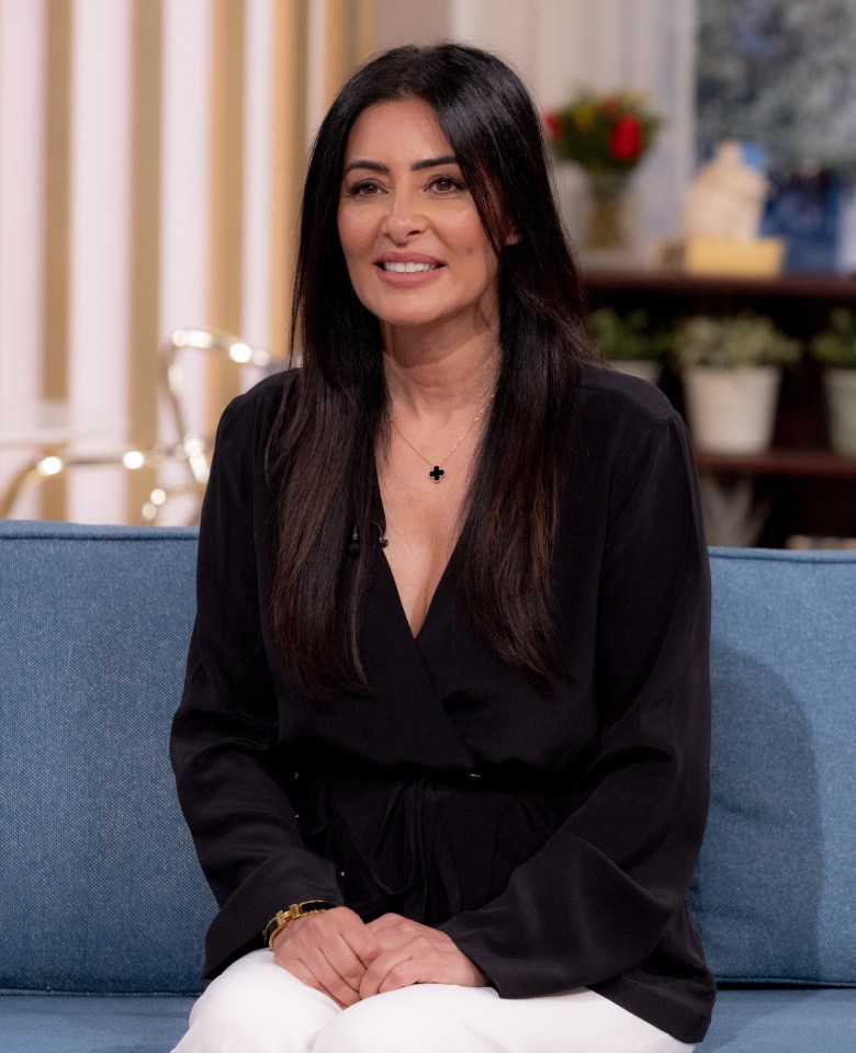 a woman is sitting on a blue couch and smiling