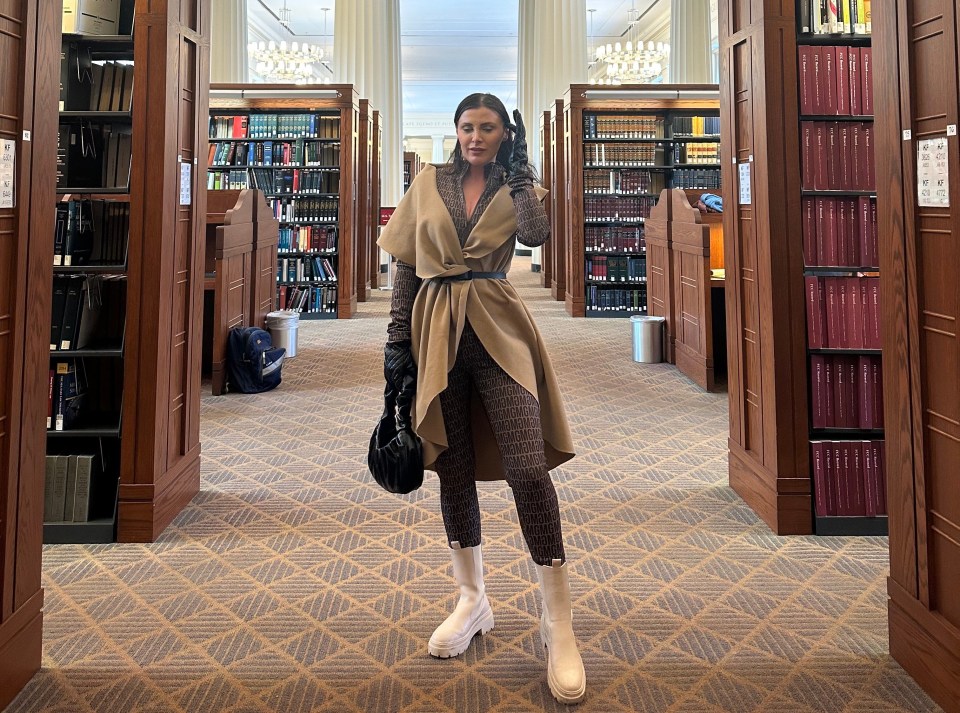 a woman is standing in a library surrounded by bookshelves