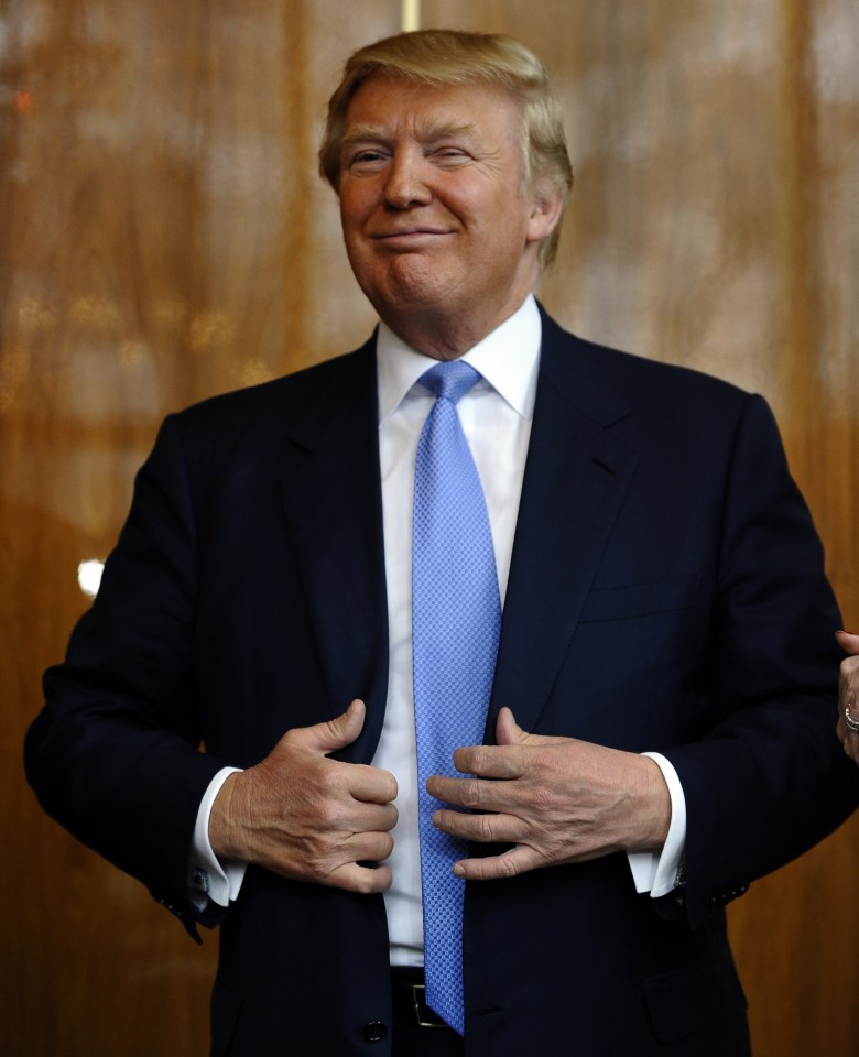 a man in a suit and tie is smiling and adjusting his jacket