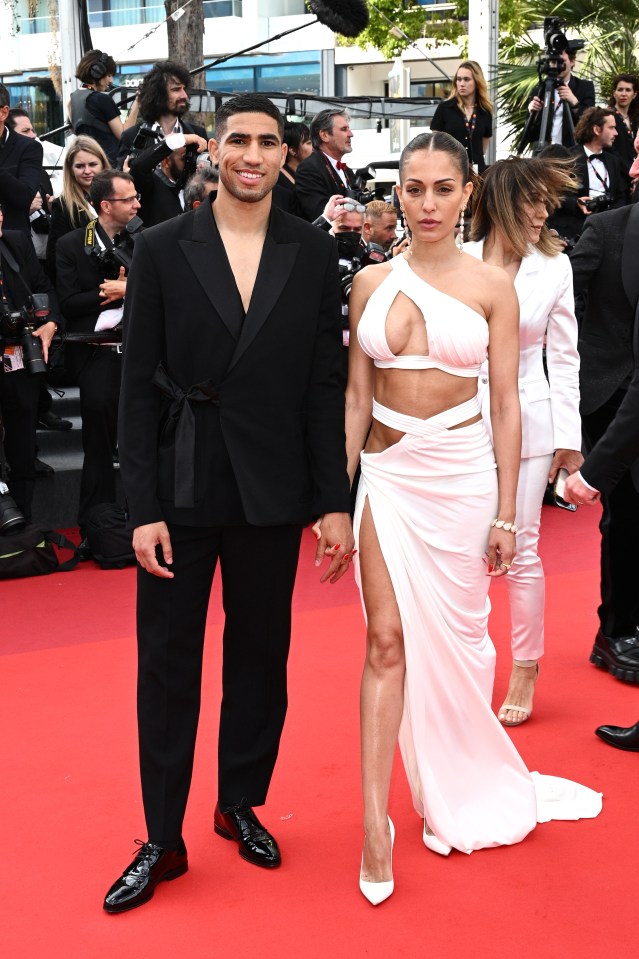 a man in a green suit and a woman in a green dress pose for a photo