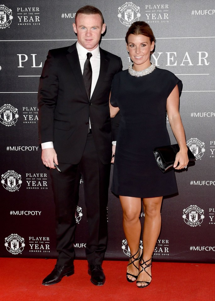 a man and woman are standing in front of a wall that says player of the year